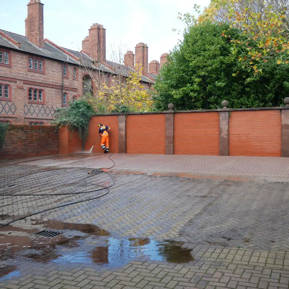 Man jet washing car park