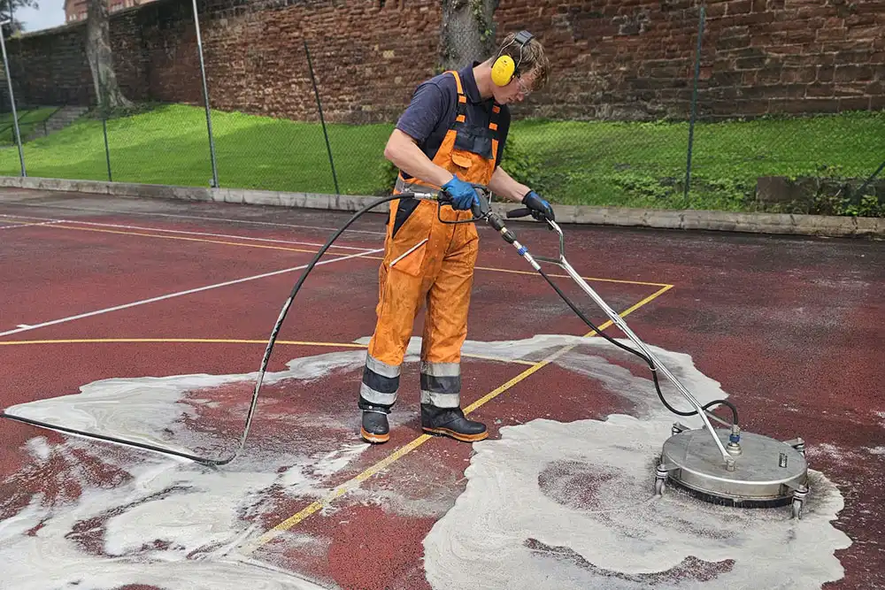 man cleaning sports court